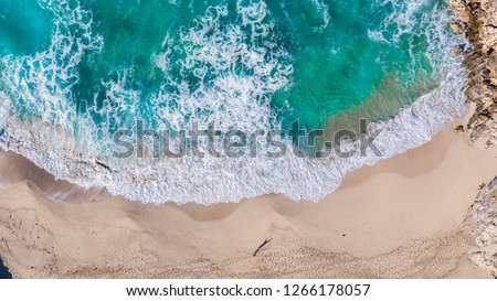 Aerial overview of huge waves crashing into the shore and rocks at Cala Mitjana, Mallorca, overview shot showing the dynamic coastline of the turquoise waters of Mallorca spain.