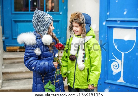The small boy gives a girl a rose. Two children. The concept of love and Valentine's Day.