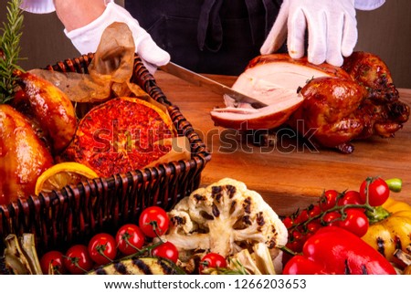 Cutting of chicken on a part on a wooden board
