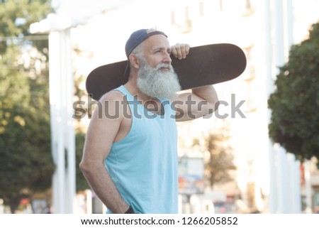 My hobby. Cheerful bearded man holding a skate while smiling to you