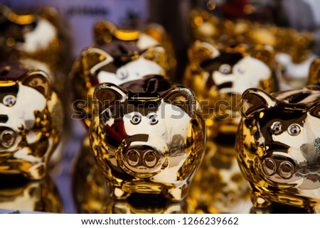 Golden piggy banks in the shape of a pig. Presents. Symbol of 2019 Royalty-Free Stock Photo #1266239662