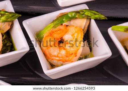 An asparagus on a grill with a shrimp