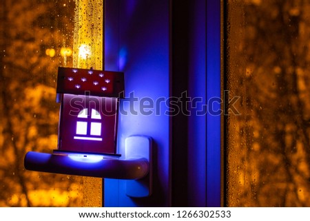 Real estate concept with a small toy wooden house on the window handle. The idea of the concept of real estate, personal property and family home.