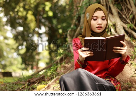 Beautiful lady wearing hijab holding book. Education concept. Beauty with brain.