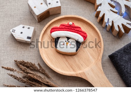 A ginger or shortbread biscuit painted in penguin wearing Santa clause hat. It looks beautiful, tasty and cute. This cookie usually given as gifts or present in on Christmas day,  New Year 2019. happy