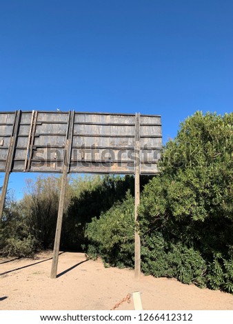 Abandoned billboard in desert near highway