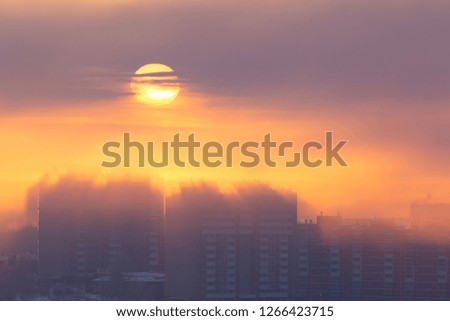 The sun rising over the buildings in the city in winter