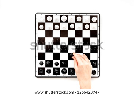 Play chess. Hand move chess figure on board on white background top view copy space