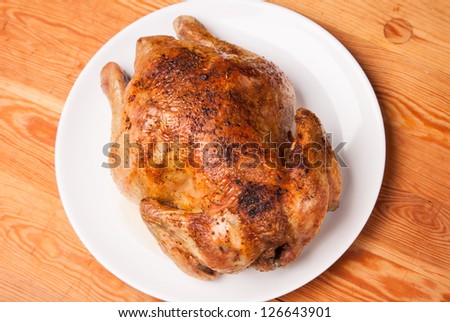 roast chicken on white plate and wooden background