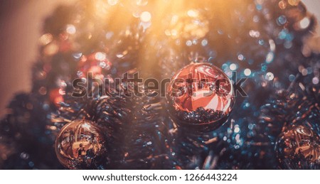 Close-up pictures of Christmas balls on a Christmas tree and a light shining on the background