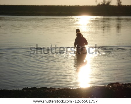 water Silhouette sunset real people sky beauty in Nature leisure activity Reflection lifestyles Sunlight men one person Royalty-Free Stock Photo #1266501757