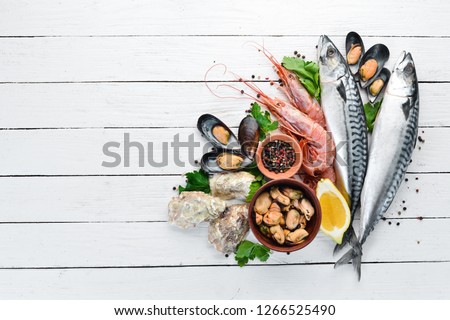 Seafood on a white wooden background. Fresh fish, shrimp, oysters and caviar. Top view. Free copy space. Royalty-Free Stock Photo #1266525490