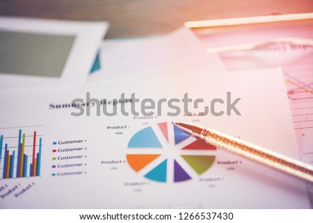 Business report chart preparing graphs concept / Summary report in Statistics circle Pie chart on paper business document financial chart and graph with  pen on the wooden table background 