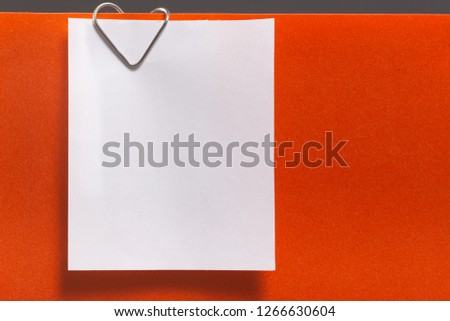 Empty sheet of  paper on a clip in the form of a heart. Blank for Valentine Day Love Card, orange background