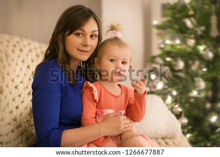 Happy little girl with her young mom on Christmas Eve