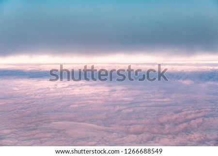 Blue sky background with pink homogeneous clouds.