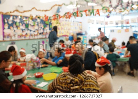 Selective focus picture of parents and children doing Christmas craft together.
