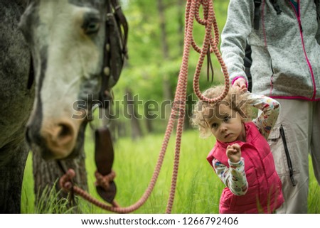 Girl having fun with mother and horse in the woods, young pretty girl with blond curly hair, freedom, joy, movement, outdoor, spring, healthy, happy family, cheerfull, kid on vacation