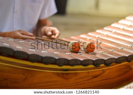 Thai classical music instrument : Hands hitting the Thai wooden alto xylophone instrument.