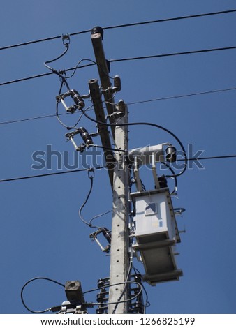 Transformer on the pole Acts to convert high voltage AC power to low voltage alternating current to supply electricity to the service provider. On the blue sky background. On the blue sky background