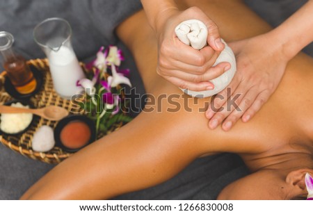 Thai Massage of  asian woman in spa room. Beautiful young woman having massage with herbal compress balls in therapy spa salon. Royalty-Free Stock Photo #1266830008