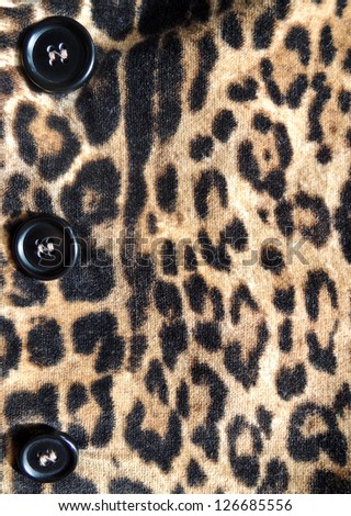 Close-up of a stylish leopard jacket with black button