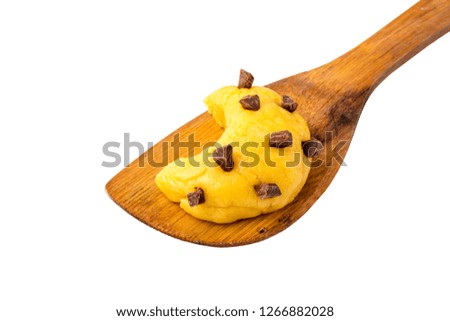 Raw cookie dough with chocolate chips in the form of the moon on a wooden blade. Isolated object