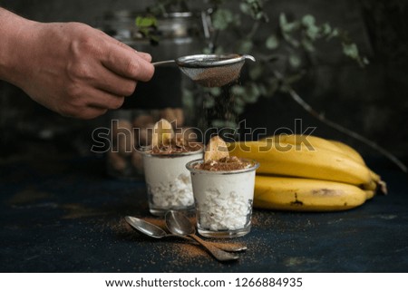 hand man of cocoa sprinkles for dessert banana. ice cream with a slice of fresh banana. Copy space