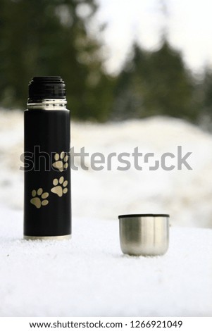 
thermos on the background of a snow-covered forest