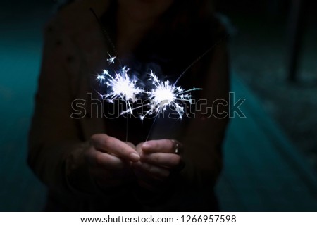 Girl at night with two sparklers