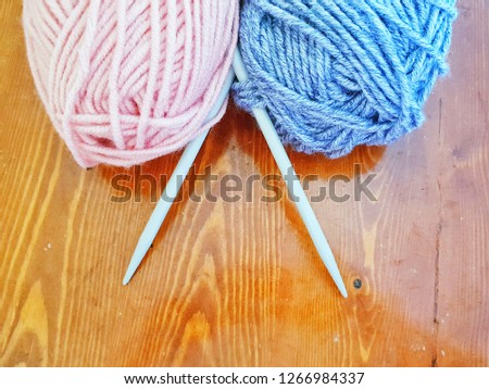 Two balls of wool with knitting needles