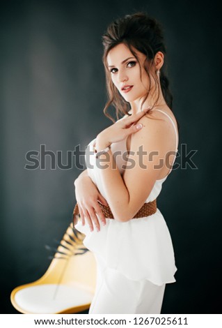 Portrait of beautiful young brunette woman with makeup in fashion clothes