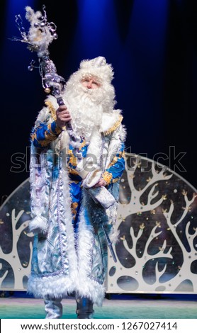 Santa Claus in blue costume performs on stage
