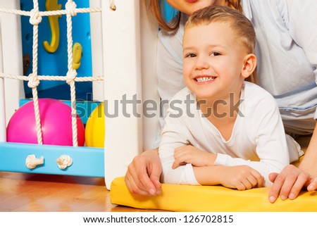 Happy mother and her five years old kid laying on the floor with just drawn picture
