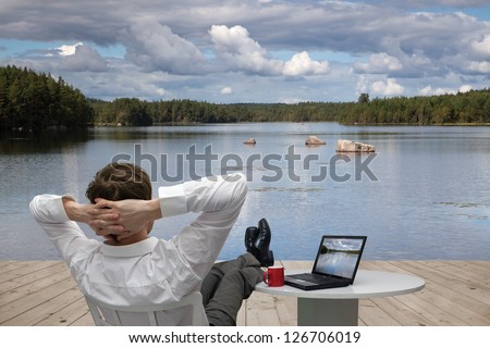Businessman resting on the shore of lake Royalty-Free Stock Photo #126706019