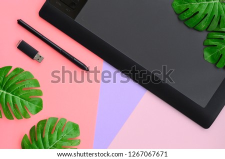 Graphic tablet and pen, memory card and monstera leafs