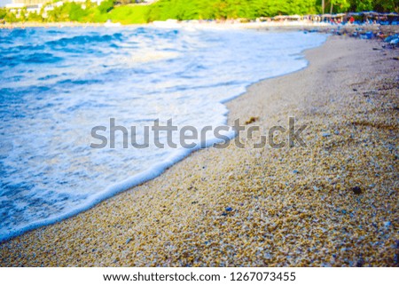 Blue colored sea waves hits the beach sands.