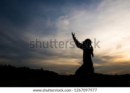 Silhouette of woman praying with god