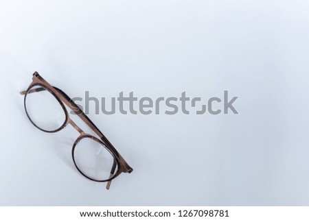Round spectacles (progressive eye glasses) at lower left corner on white background