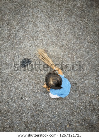 A girl using traditional sweeping broom