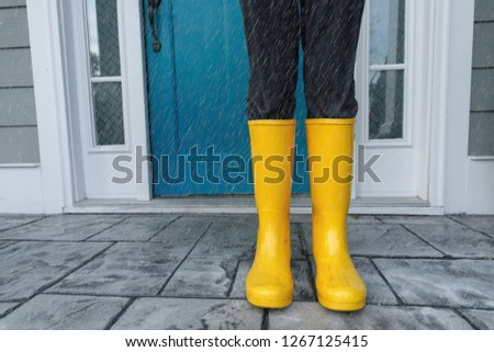 Yellow Wellies  Rainboots Outside on the wet Porch while raining Royalty-Free Stock Photo #1267125415