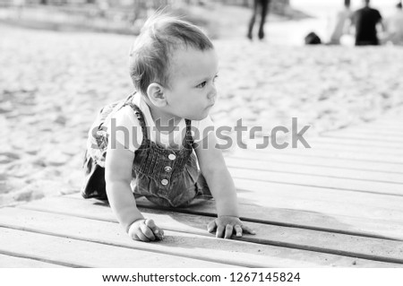 baby girl playing sand on the beach