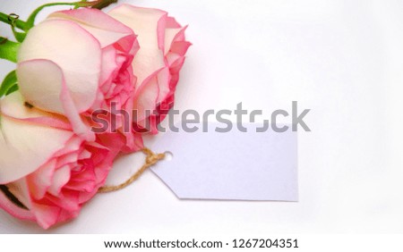 pink roses and tag pattern on white background selective focus