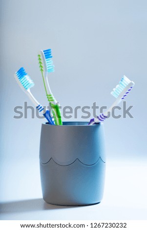 a toothbrushes in a cup on blue background