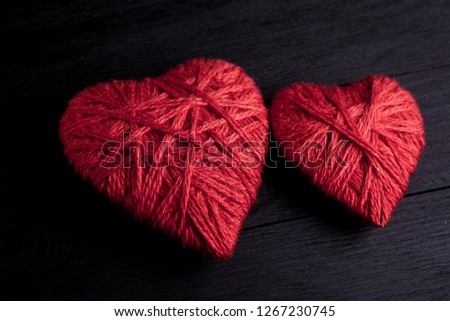 Valentine day postcard with handmade red hearts on black wooden background
