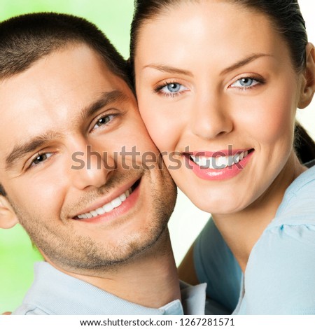 Young happy smiling attractive couple, outdoors. To provide maximum quality, I have made this image, by combination of three photos. You can use left part for slogan, big text or banner.