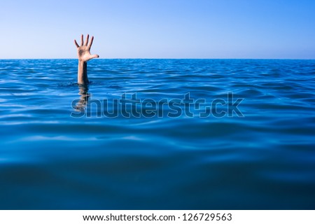 Help needed. Drowning man's hand in sea or ocean. Royalty-Free Stock Photo #126729563