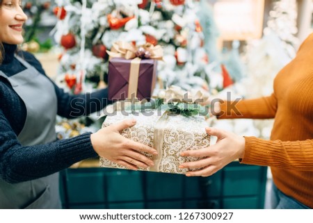 Wrapping service seller gives to customer gift box