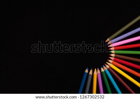 Colored pencils on black background. Palette of color pencils on a black background, stock photo