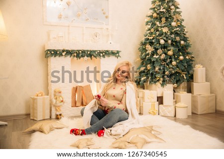 Pregnant woman in christmas time spend time in her house